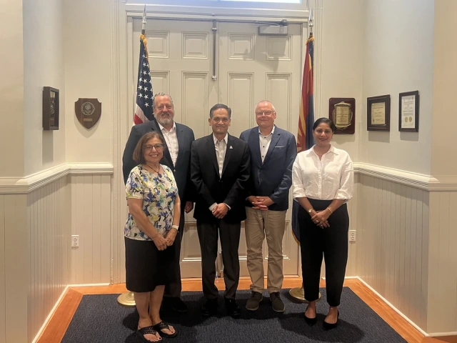 A group of five individuals smiling inside of Old Main 