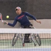 A photograph of a man about to hit a tennis ball