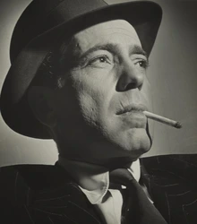 A portrait of Benn Mitchell, wearing a hat with a cigarette in his mouth.