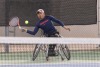 A photograph of a man about to hit a tennis ball
